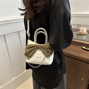 Sac chic en cuir blanc avec nœud en tissu vert et chaîne argentée en décor intérieur