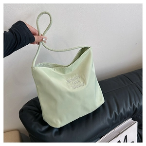 Detailopname van de lichtgroene nylon draagtas met 'pretty and libety' borduursel erop