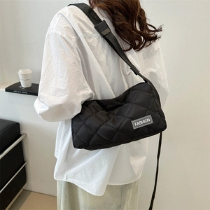 Minimalist black quilted nylon tote bag with rhombus pattern and adjustable shoulder strap