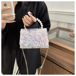 Close-up of colorful sequins and pearl handle on a trendy designer women handbag