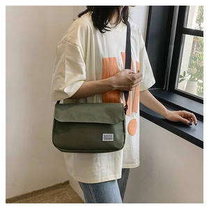 Detail of army green canvas messenger bag with Black Rice label on adjustable strap