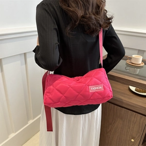 Stylish rose pink quilted tote bag with diamond pattern shown on model in cozy room