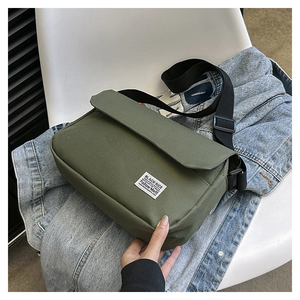 Detail of army green canvas messenger bag with adjustable strap and vintage label