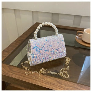 Macro detail of iridescent sequins and faux pearl handle on a luxury mini handbag
