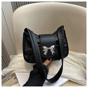 Detail of black leather half-moon shoulder bag with silver metal bow buckle and pleats