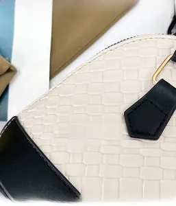 Détail du sac tressé avec texture en cuir crème et garnitures métalliques dorées