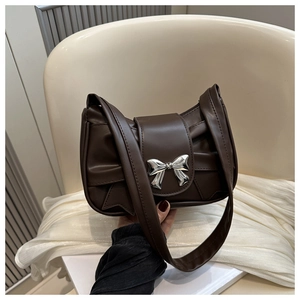 Detail of dark brown ruched shoulder bag featuring a decorative silver bow metal buckle