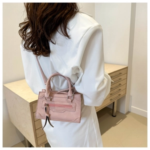Gros plan du mini sac à main rose avec détails de fermeture éclair et bandoulière fine
