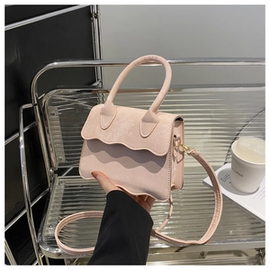 Detailed close-up of pink handbag featuring unique scalloped edges and matte texture