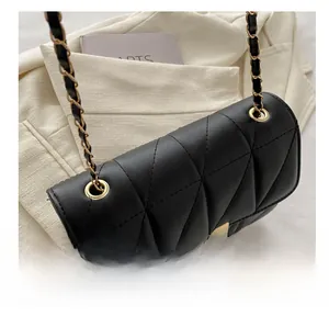 Detail showing perforated gold eyelets and leather chain strap on black quilted bag
