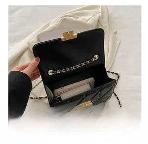Internal view of black quilted flap bag showing capacity for smartphone and accessories