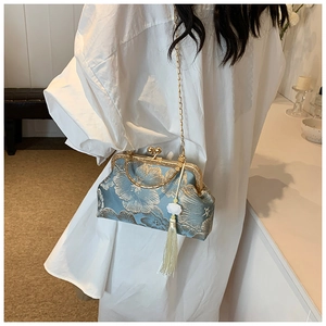 Detail of light blue floral jacquard evening bag with white tassel and gold chain