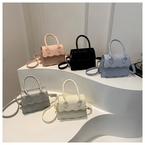 Detailed display of five small crossbody bags in varied colors on a curved pedestal