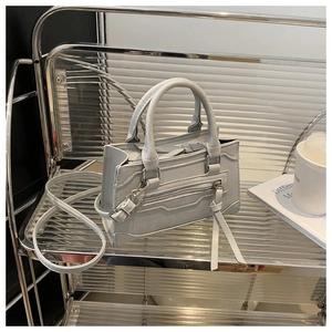 Détails du sac Boston gris clair avec ailes latérales et longs pompons sur les fermetures