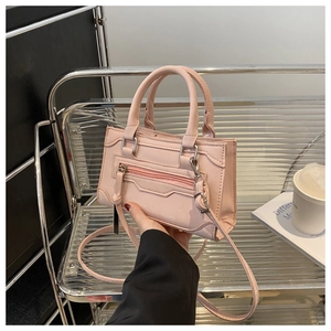 Détails du sac à main rose avec fermetures éclair et bandoulière amovible