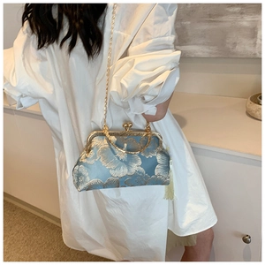 Detailed close-up of retro jacquard embroidery bag with golden heart lock and silk tassel