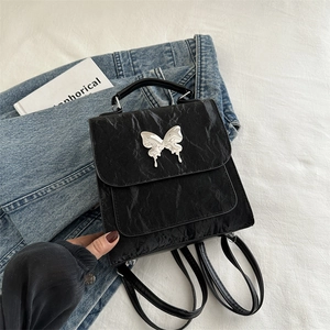 Minimalist black crinkle leather women's backpack with silver butterfly buckle