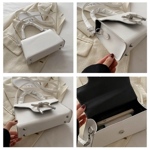Detailsicht der weißen Rafftasche mit Strass-Schleife und silbernen Standfüßen