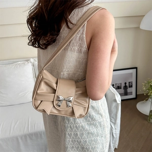 Elegant apricot shoulder bag with bow knot detail and metallic butterfly clasp
