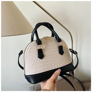 Détail d'un sac à main bicolore chic en forme de coquille avec texture crocodile