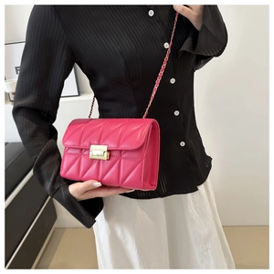 Detail of rose pink quilted crossbody bag with gold chain strap and twist lock