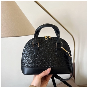 Vue détaillée du sac coquillage noir avec texture tressée et finitions dorées