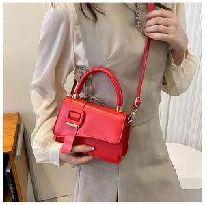 Fashion red leather bag with square buckle shown as a crossbody on a female model