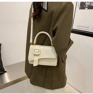 Minimalist beige shoulder bag shown in a stylish minimalist setting on a model