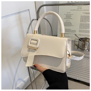 Detail view of a creamy white handbag with a large square buckle and matte PU leather finish