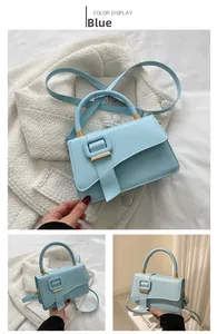 Detail of light blue faux leather handbag with circular handle and adjustable shoulder strap
