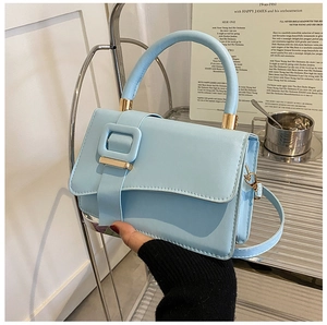 Light blue faux leather handbag featuring a large square buckle and gold metal accents