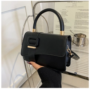 Close-up of minimalist black matte PU leather handbag with elegant gold metal square buckle