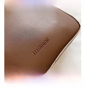 Macro shot of brown lychee-textured leather with JIASHIQING logo and precise stitching