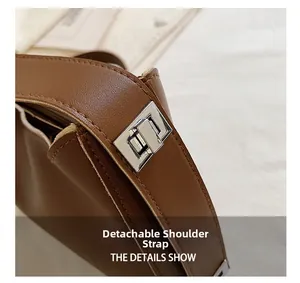 Detailed close-up of brown leather bag with silver metal buckle and detachable strap