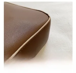 Macro detail of the brown lychee grain leather stitching and high-quality edge craftsmanship
