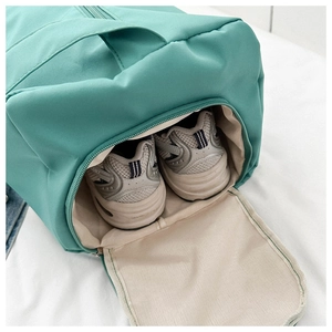Detail of mint green travel bag featuring a specialized side compartment for shoes