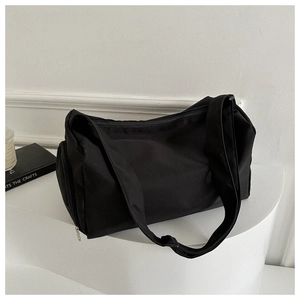 Close-up of black nylon travel bag featuring reinforced zippers and durable shoulder strap