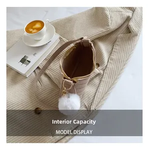 Vue intérieure d'un sac cabas marron clair avec fermeture éclair et pompon en peluche