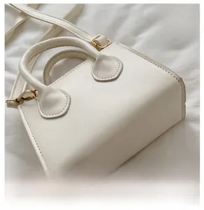 Detailed close-up of cream PU mini square bag showing the base and adjustable strap
