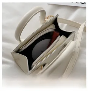 Internal view of cream white mini crossbody bag showing zippered compartment and space