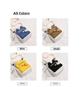 Detail van de kleine canvas crossbodytas met kleurrijke flappen en schattige 3D-bedels