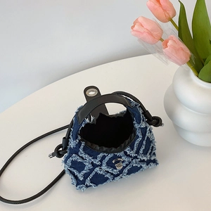 Sac seau en denim bleu foncé avec texture matelassée et fermoir métallique argenté