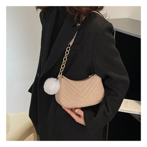 Detail of beige crescent underarm bag with V-quilted texture and gold chain strap