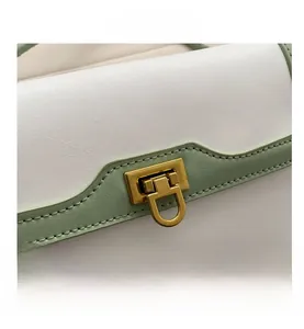 Detail of white and green leather handbag with lychee texture and gold metal clasp