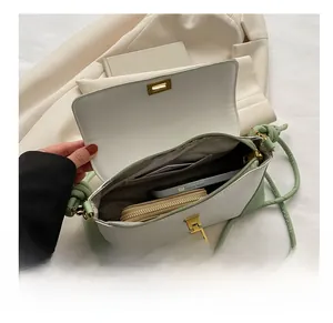 Detail showing the internal storage space with a phone and wallet in the crossbody bag