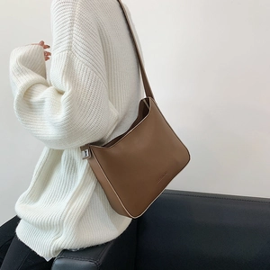 Minimalist brown leather underarm bag with polished finish and shoulder strap styling