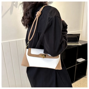 Detail of white and brown crossbody bag featuring a gold metal buckle and knotted strap