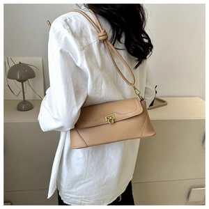 Detailed view of beige underarm bag showing fine leather texture and gold metal buckle