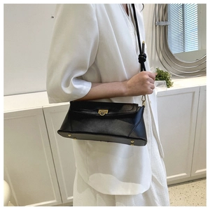 Detail view of the black retro baguette bag with gold buckle and bottom protective studs