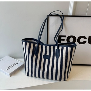 Close-up of blue and white striped canvas tote bag on a minimalist display stand